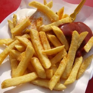 Delicious crispy French fries served with ketchup and mayonnaise on a paper plate